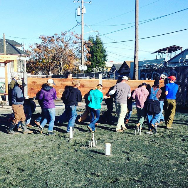 In Good Company volunteers carrying the first completed planter box for the community garden.