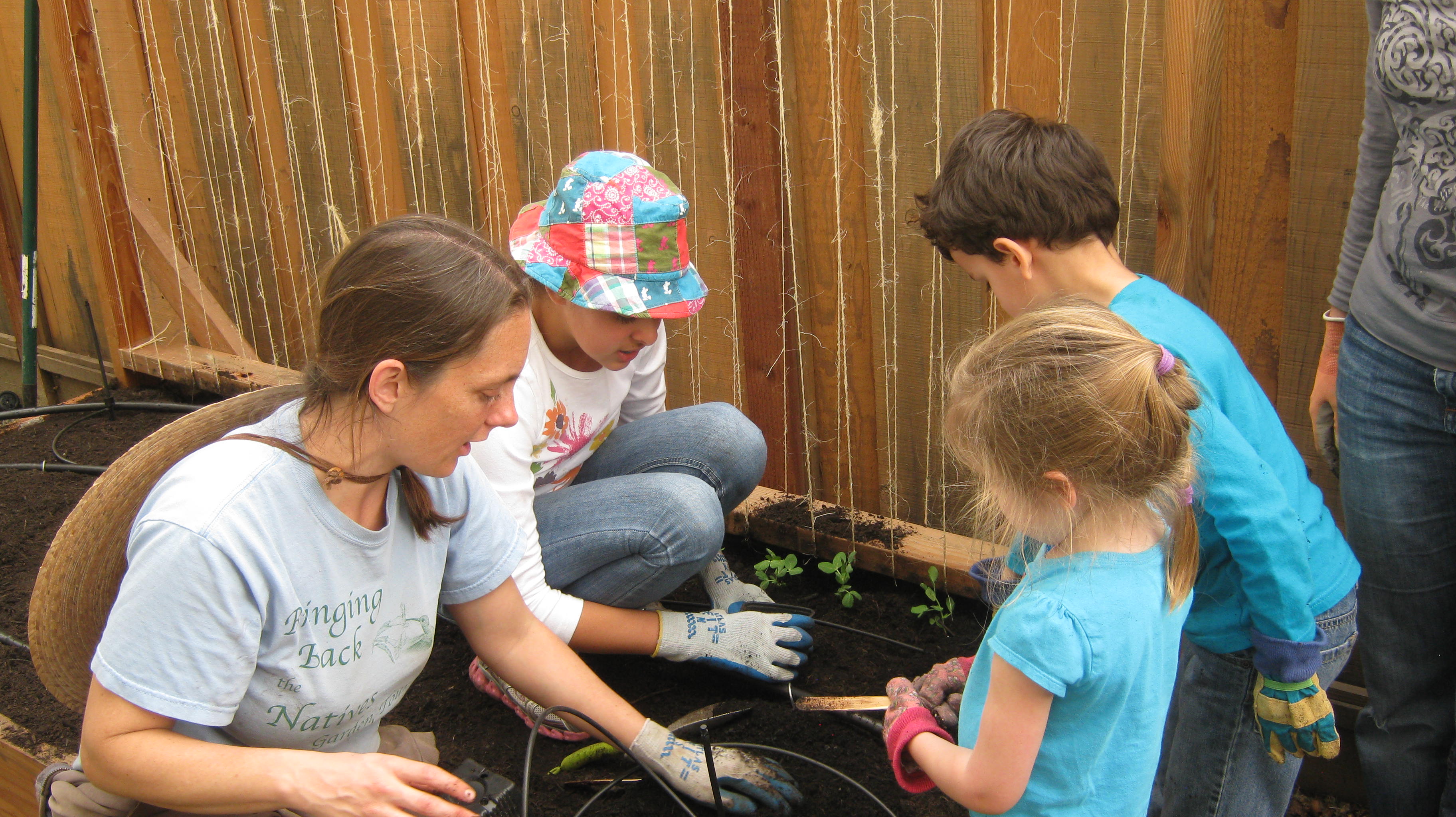 Sarah planting with kids at Annie's Playhouse childcare center