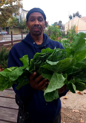 Ron, owner of Ron's Pit Stop, shows off his collard greens at farm stand